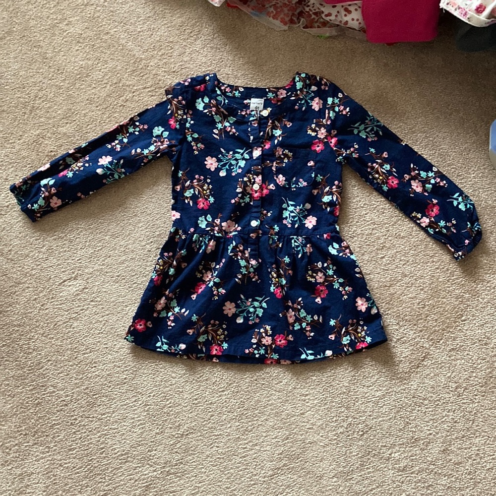 Never wore. Shirt flares out at the end. Arm ruffled. Navy blue/pink. Girl.